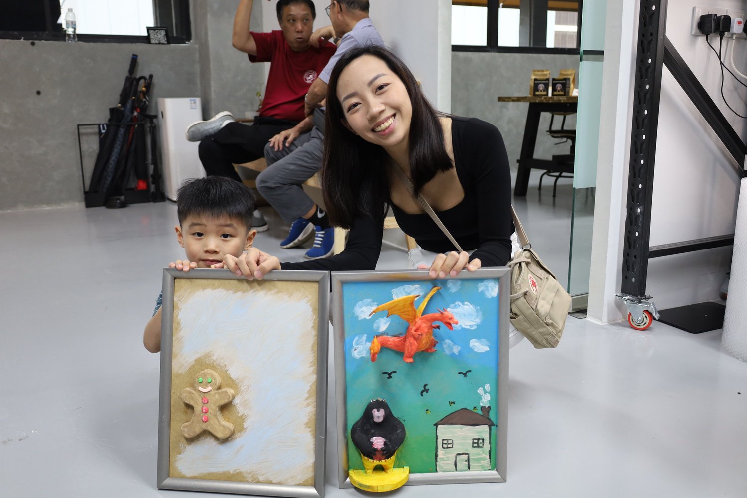 A group holding up finished 3D canvases at a birthday session in Singapore